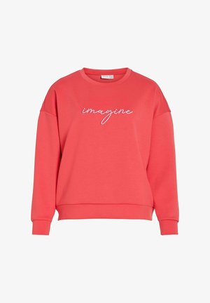 Koralowa bluza dresowa o luźnym kroju, z zaokrąglonym dekoltem i raglanowymi rękawami. Na przodzie w białym haftowanym napisie widnieje słowo "Imagine".