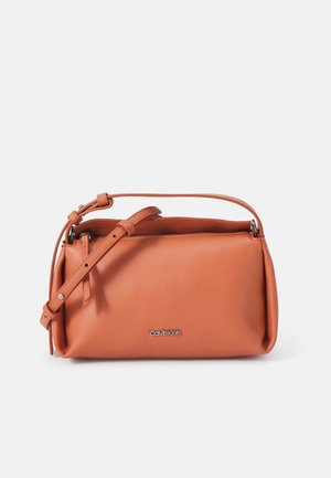 Kleine rechthoekige schoudertas van glad leer in camel met verstelbare band en zilverkleurig Calvin Klein-logo aan de voorkant.