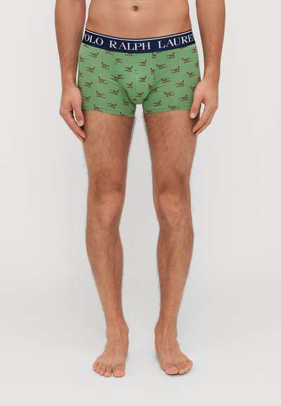Boxer shorts verts avec un motif de chiens espiègles. Dispose d'une ceinture élastique bleu marine avec le logo "POLO RALPH LAUREN".
