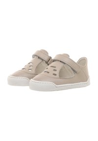 Zapatos de cuero beige con una correa de velcro, agujeros de ventilación troquelados y suelas de goma blanca, con una puntera redondeada y un diseño minimalista.