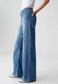 Weite Denim-Jeans in Hellblau. Mit hoher Taille, zwei Gesäßtaschen und einer glatten Textur, die eine gerade, lockere Passform von der Hüfte bis zum Saum bietet.