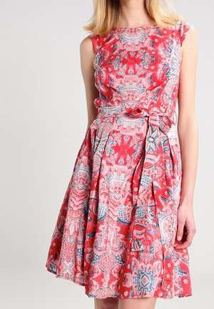 Rotes Kleid mit enganliegendem Oberteil und weit schwingendem Rock, das komplizierte florale und geometrische Muster in Blau- und Rosatönen zeigt. Glatte Textur.