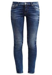 Jeans ajustados de mezclilla en un color azul medio con un ligero desgastado. Cuenta con cinco bolsillos y costuras en color naranja en contraste. Cintura clásica.