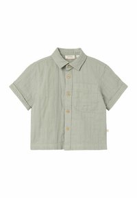 Camicia a maniche corte in cotone verde chiaro con taschino frontale, bottoni in legno e colletto. Texture morbida e vestibilità rilassata.