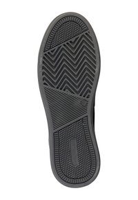 Semelle de chaussure en caoutchouc noir avec un motif de crampons en zigzag et des accents circulaires ; présente des détails de marque près du talon.