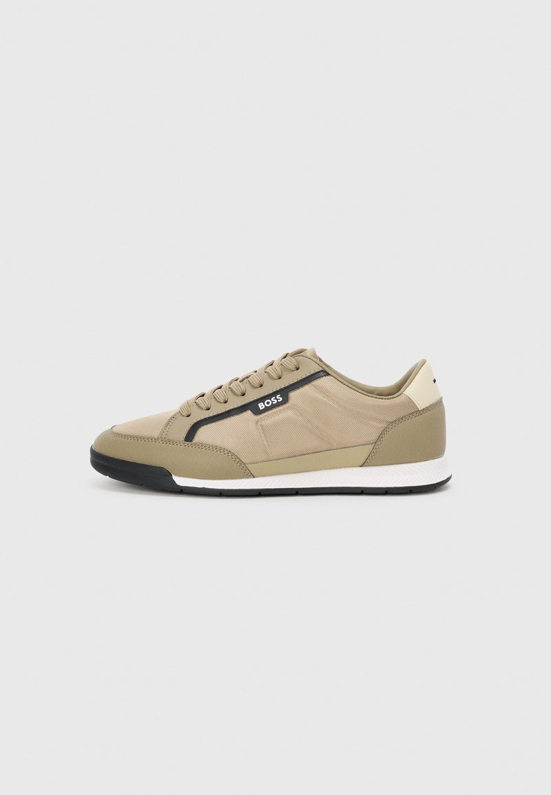Brune sneaker med en teksturert stoffoverdel, sorte detaljer og en hvit såle. Har snøring og logo på siden.