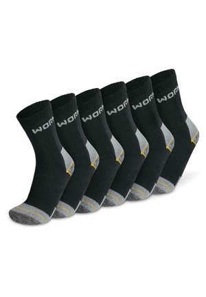 Sechs Paar schwarze Socken mit gerippter Textur, grauen Akzenten an Ferse und Zehen sowie gelben Streifen an der Sohle. "WORK" in Weiß auf dem Bündchen gedruckt.