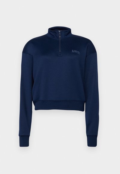 Navy blue zip-neck sweatshirt made of soft fabric, featuring long sleeves and a cropped design with a ribbed hem and cuffs.