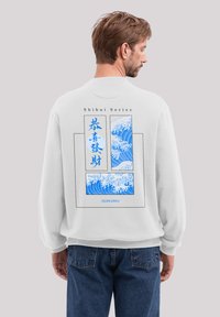 White sweatshirt featuring blue wave graphic with Japanese text on the back. Loose fit, soft texture, ribbed cuffs, and hem.