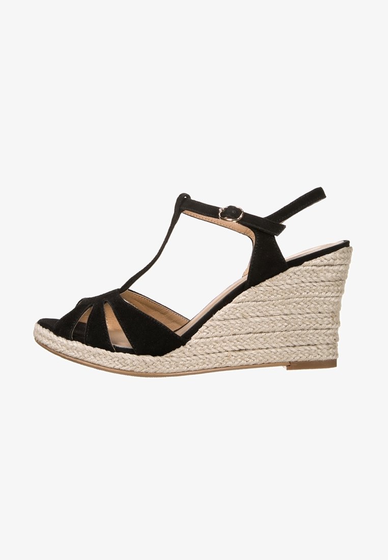 Sandal con zeppa nera in suede, design con tracolla a T, punta aperta e tacco a zeppa in iuta intrecciata. Presenta una cinghia alla caviglia regolabile e una suola testurizzata.