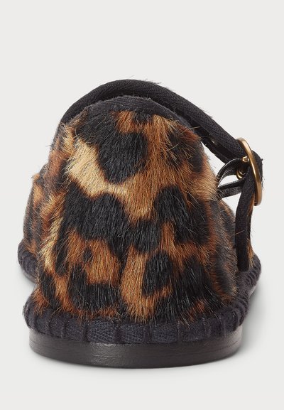 Vista traseira de um chinelo com pelagem sintética de leopardo, sola preta e uma tira preta com um fecho de latão.