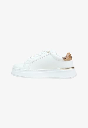 Witte lage sneaker met dikke zool, witte veters en een hielaccent met een bruin patroon en metalen gouden rand.