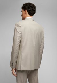 Beige Sakko mit strukturiertem Finish, einziger Schlitz an der Rückseite und Drei-Knopf-Manschetten. Maßgeschneiderte Passform mit einer markanten Silhouette.