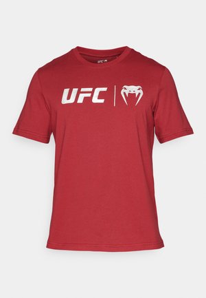 Raudona trumpomis rankovėmis medvilninė marškinėliai su "UFC" logotipu ir stilizuoto gyvūno veido dizaino elementu ant priekio.