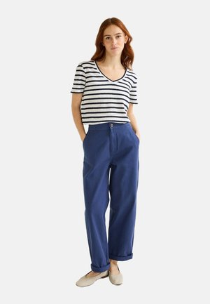 Pantalons évasés bleu marine avec des ourlets roulés, associés à un haut à manches courtes en V rayé blanc et bleu marine. Mélange de coton doux et décontracté.