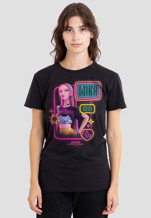 Young woman wearing a black T-shirt with colorful neon-style K-pop Demon Hunters character, text "MIRA," and Korean script.