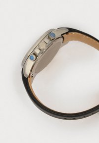 Ρολόι από ανοξείδωτο ατσάλι με μαύρη δερμάτινη λουρί. Διαθέτει τρία κουμπιά με μπλε λεπτομέρειες και κυκλικό καντράν. Λείο υλικό, μοντέρνος σχεδιασμός.