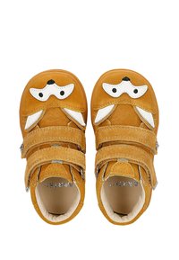 Scarpe per bambini in suede senape con dettagli bianchi. Due cinturini regolabili in velcro, punta rotonda e design di faccia di animale con orecchie.