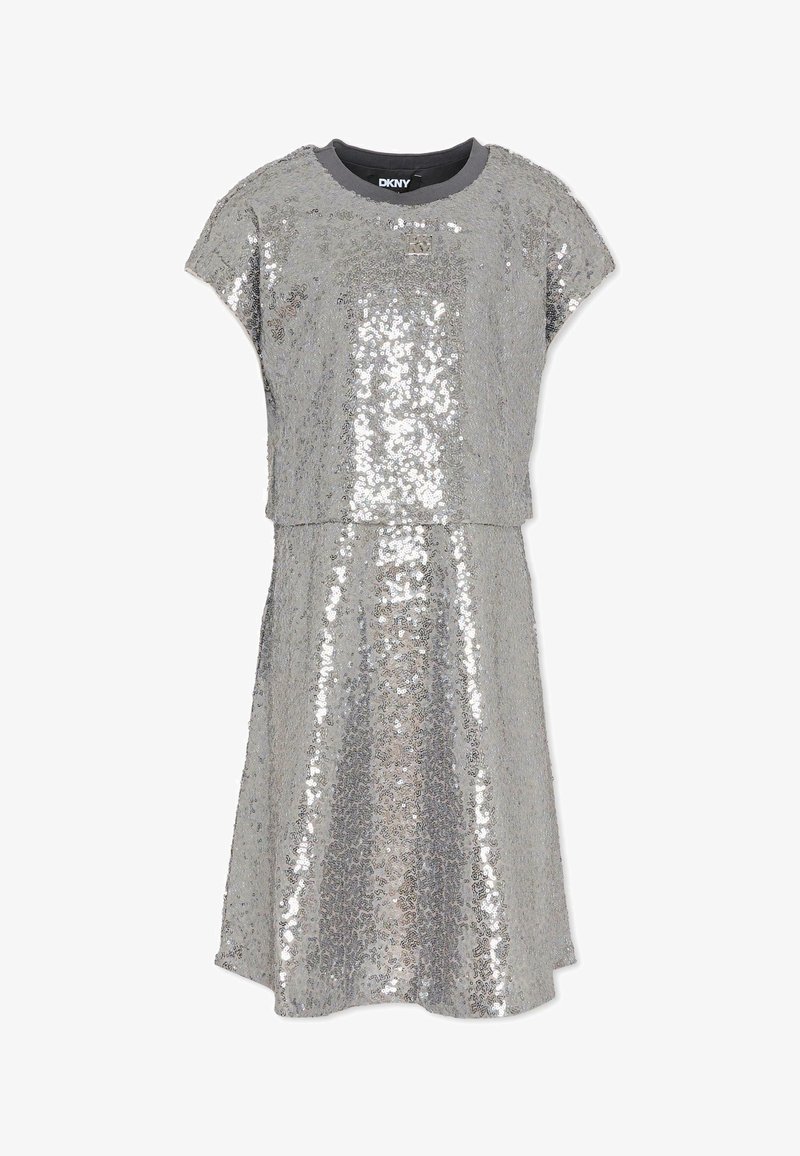 Srebrna sukienka z cekinami, z okrągłym dekoltem i krótkimi rękawami. Górna i dolna część są oddzielone poziomą linią na wysokości talii.