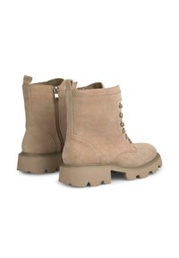 Stivali alla caviglia in suede beige con suola in gomma spessa, design con laccio frontale e zip laterale per una facile vestibilità. Superficie testurizzata e costruzione robusta.