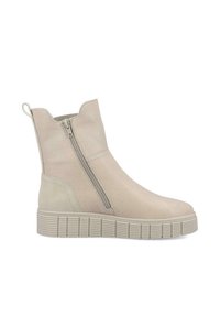 Botines beige de cuero suave, con cierre lateral, suela texturizada con estrías horizontales y un tacón corto y redondeado.