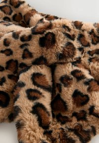 Blød, plysset kunstpels med et leopardmønster i nuancer af brunt, sort og tan, arrangeret i folder.