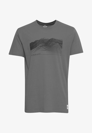 Camiseta de algodón gris con un gráfico de paisaje montañoso en negro. El texto abajo dice "no hoy, mañana sí". Mangas cortas y cuello redondo.