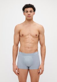 Lys blå tettsittende boxershorts laget av mykt stoff, med en glatt tekstur og elastisk midjebånd med preget logo.