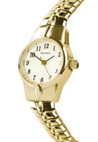 Montre-bracelet dorée avec un cadran rond, un cadran blanc avec des chiffres arabes noirs, et un bracelet en maillons au design brillant.