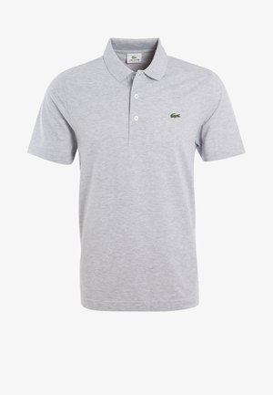 Polo à manches courtes gris clair avec deux boutons blancs et logo crocodile vert sur la poitrine gauche.