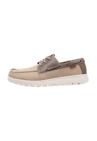 Zapatos de barco casuales en beige y gris con una textura suave, detalles en cuero color tostado y cordones trenzados. Suela de goma con patrón de relieve visible.