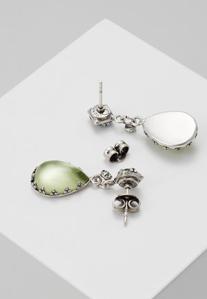 Silberne Ohrhänger mit grünen Tropfensteinen und Schmetterlingsverschluss auf weißer Oberfläche.