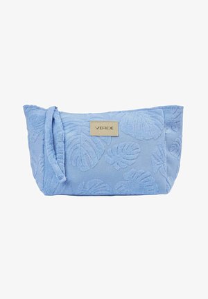 Bolsita de tela azul clara con patrones de hojas en relieve, una correa para la muñeca en el lateral y una etiqueta beige con la palabra "VERDE" en el frente.