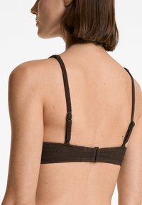 Barna, textúrált melltartó vékony pántokkal és kapoccsal. Kiváló minőségű szőtt anyagból készült, állítható pántokkal a biztonságos illeszkedés érdekében.