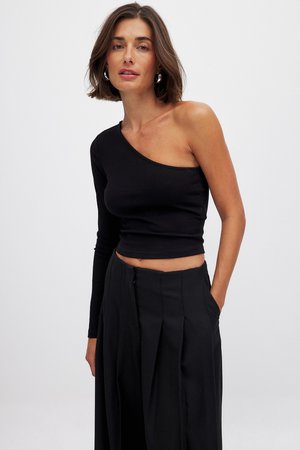 Sort ribbet en-skulder crop top med lang ærme, der har et figursyet design og glat overflade, sammen med høj TALJE sorte bukser.