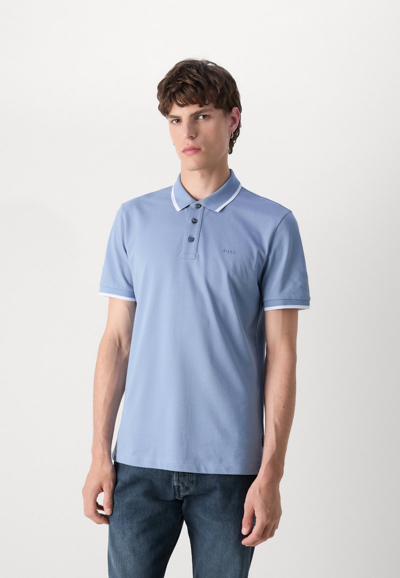 Polo bleu clair en coton avec une patte de boutonnage à trois boutons, col blanc et accents de manches, et logo brodé sur la poitrine.