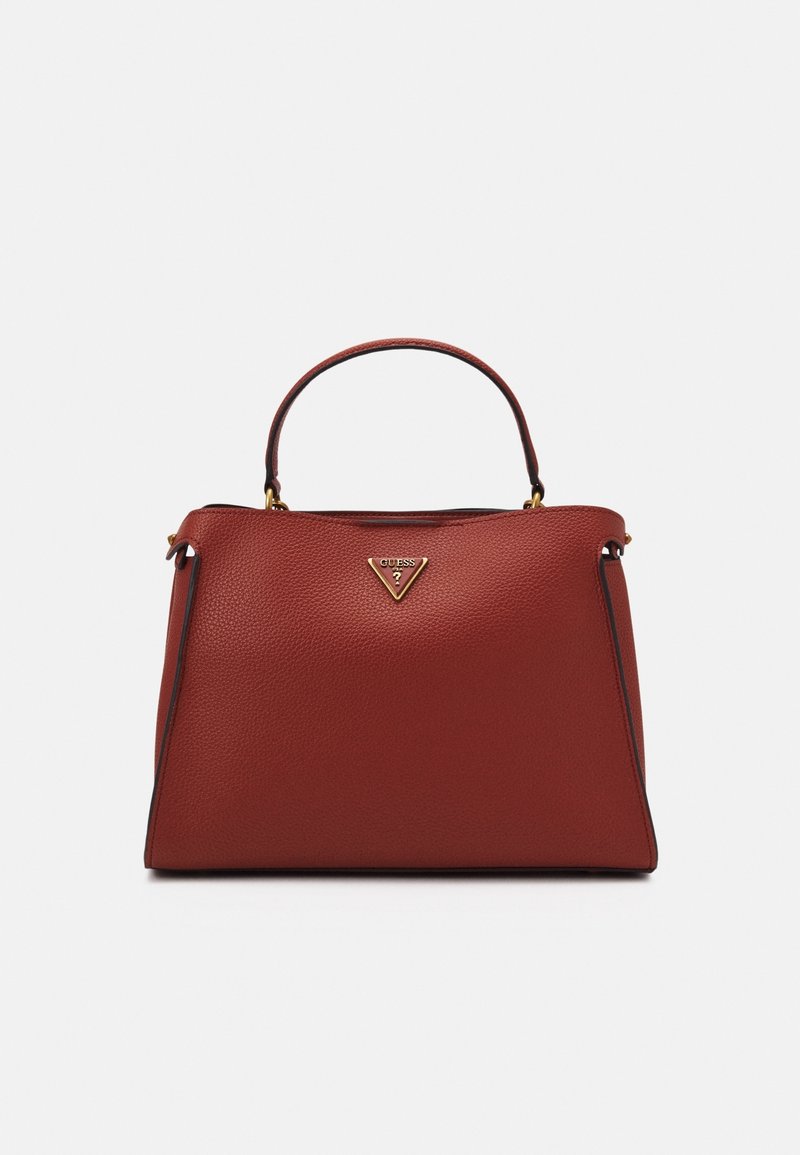 Sac à main en cuir rouge texturé avec une anse unique sur le dessus, forme trapézoïdale et logo triangulaire doré Guess au centre devant.