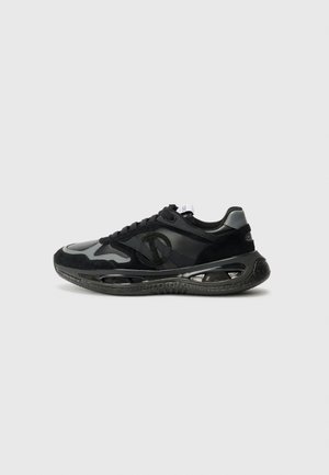 Sneaker nero e grigio che presenta un mix di materiali scamosciati e sintetici, punta arrotondata, suola intermedia testurizzata ed elementi di ammortizzazione ad aria visibili.