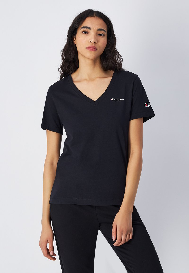 T-shirt nero in cotone con scollatura a V, maniche corte e un piccolo logo Champion sul lato sinistro del petto e sulla manica. Tessuto morbido.