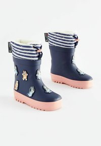 Stivali di gomma navy impermeabili con suole rosa, polsini a righe navy trapuntati e applicazioni di animali dei cartoni animati sui lati. Fodera in pelliccia per il calore.