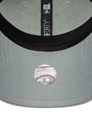 Intérieur d'une casquette de baseball grise avec une bordure noire et un autocollant rond d'authenticité Major League Baseball sous la visière.