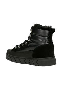 Zwarte hoge laarzen van lakleer en suede, met metalen oogjes, een gestructureerde zool en een nepbont kraag.