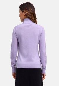 Maglione lilla con collo alto, maniche lunghe e orlo a costine. Realizzato in un morbido tessuto testurizzato. Senza motivi o dettagli visibili.