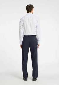 Camicia a righe azzurra chiara con maniche lunghe, abbinata a pantaloni blu navy. Include un taglio aderente e due tasche posteriori.