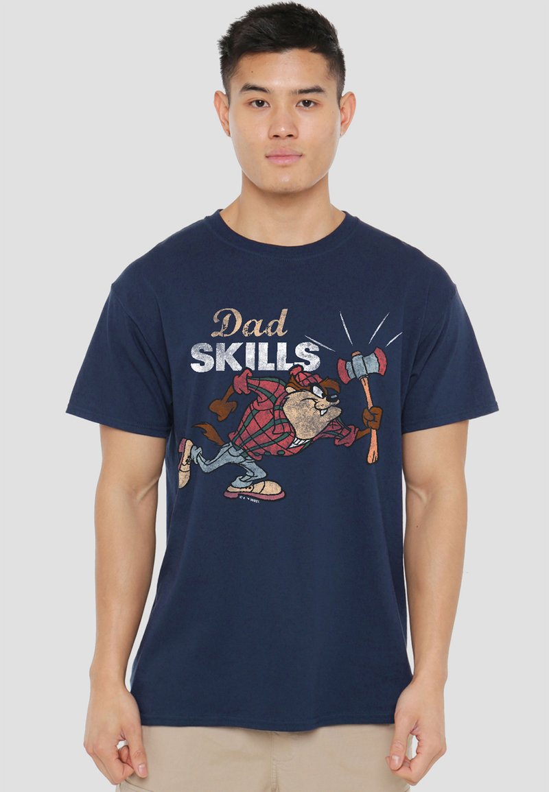 Young man wearing a navy blue T-shirt with a cartoon beaver holding an axe and the text "Dad Skills" printed on the front.