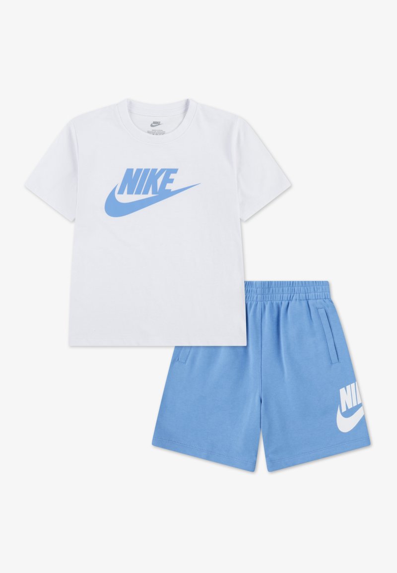 Λευκό βαμβακερό t-shirt με μπλε λογότυπο Nike, συνδυασμένο με μπλε σορτς που έχουν λευκό λογότυπο Nike. Απαλό, casual και άνετο σχέδιο.