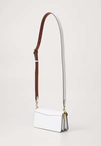 Witte leren handtas met een gestructureerd ontwerp, voorzien van een bruine verstelbare schouderband, gouden accenten en subtiele stiksels.