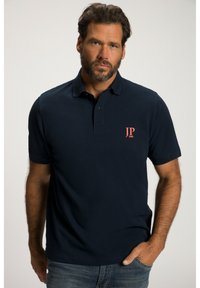Polo-shirt bleu marine en coton à manches courtes, avec une patte de boutonnage à trois boutons et un logo rouge brodé sur la poitrine gauche.