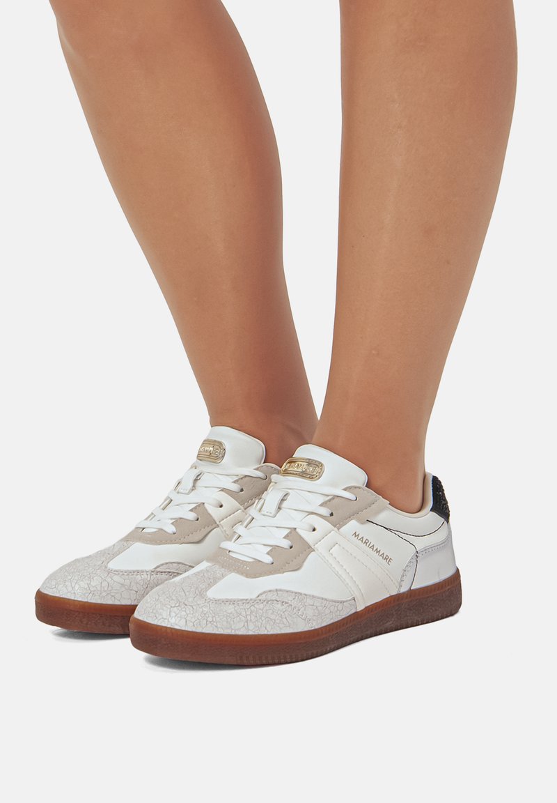 Weiße und beige Sneakers mit strukturierten Mustern, weißen Schnürsenkeln und braunen Gummisohlen. Der Markenname "MARIAMARE" ist an der Seite sichtbar.