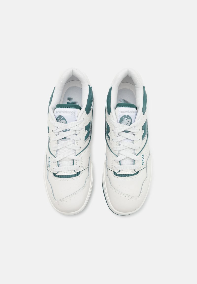 Baskets blanches avec des accents teal, dotées d'une tige en cuir lisse, de détails perforés sur la boîte à orteils et d'un branding emblématique sur les côtés.